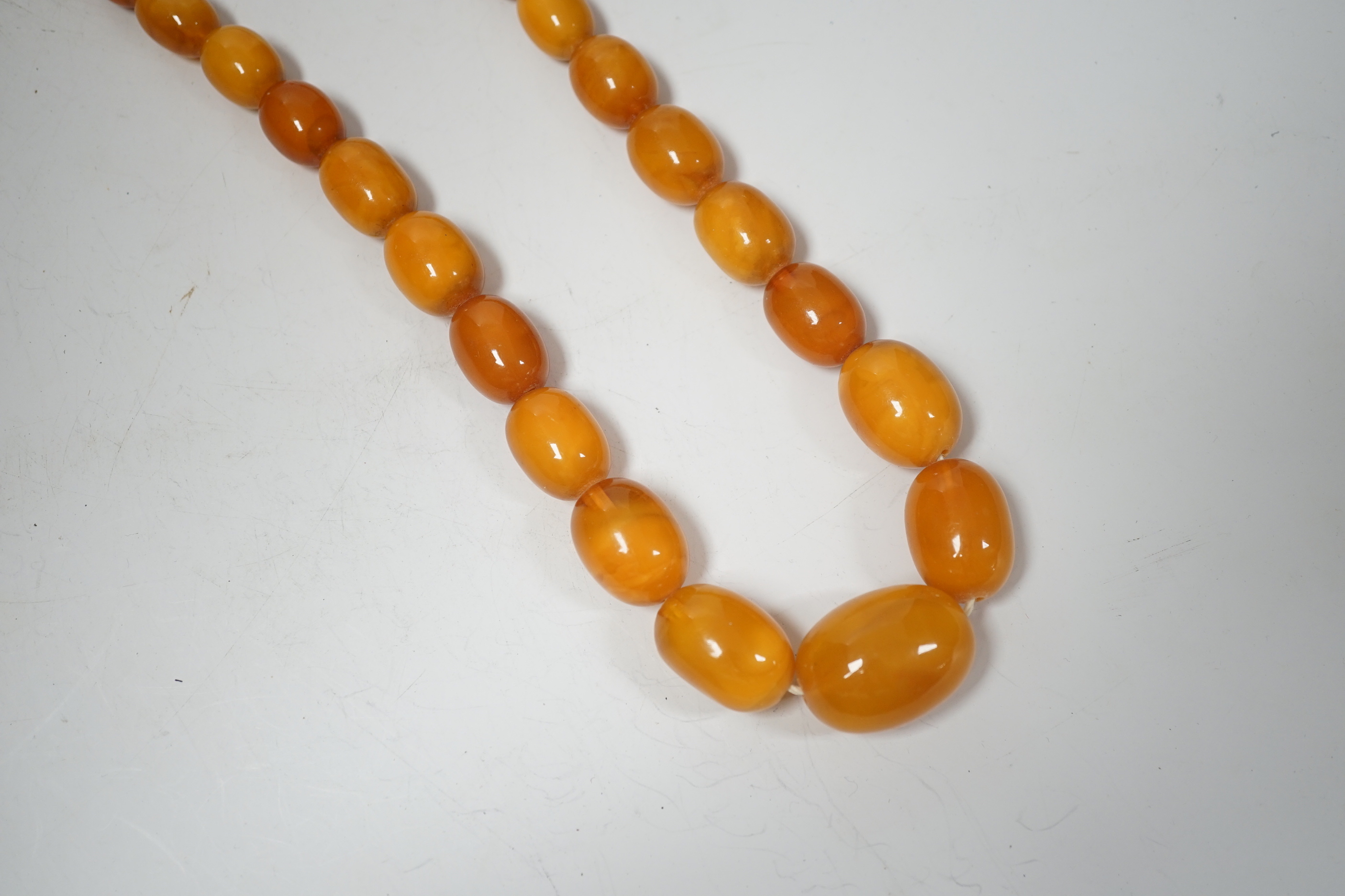 A single strand graduated oval amber bead necklace, 74cm, 83 grams.